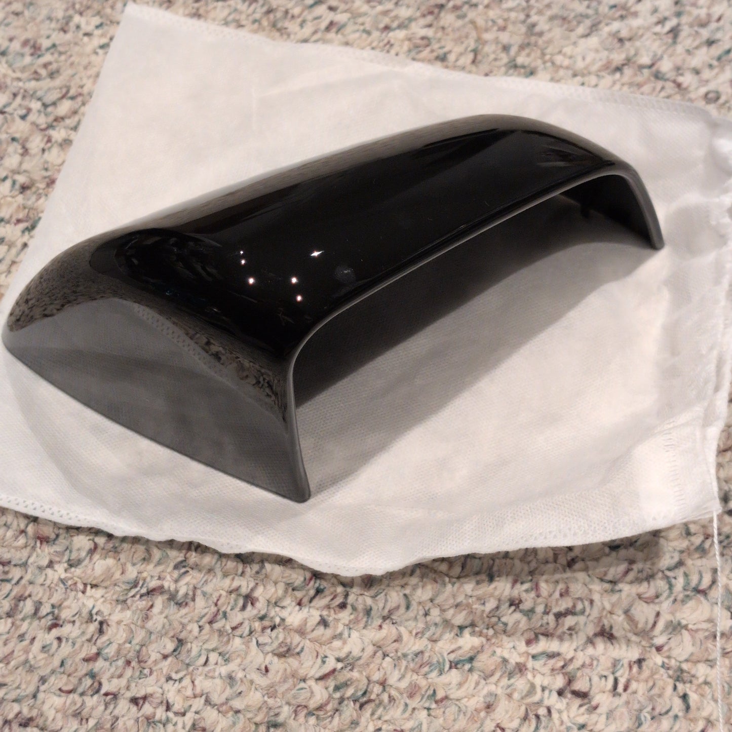 Black car wing mirror on a white towel with a textured surface background